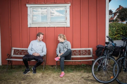 Ett par som cyklar och har tagit rast vid en bänk.