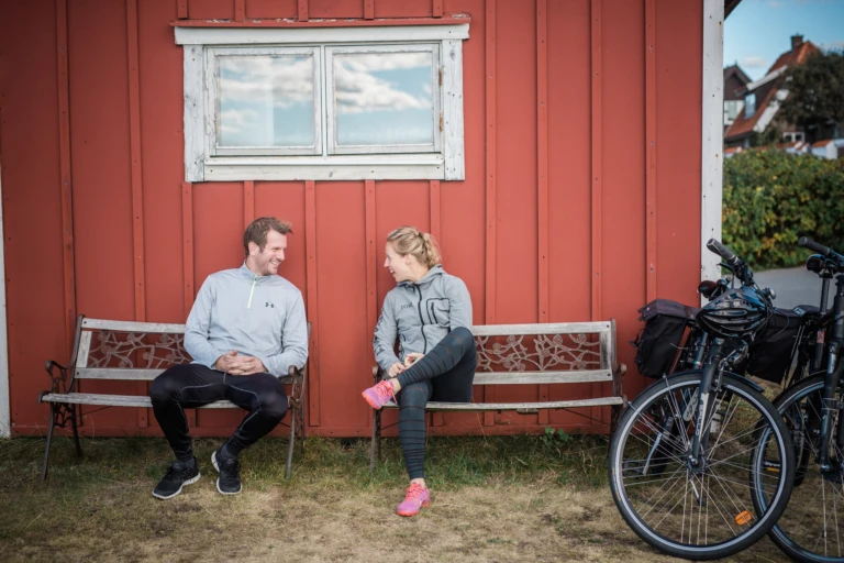 Ett par som cyklar och har tagit rast vid en bänk.