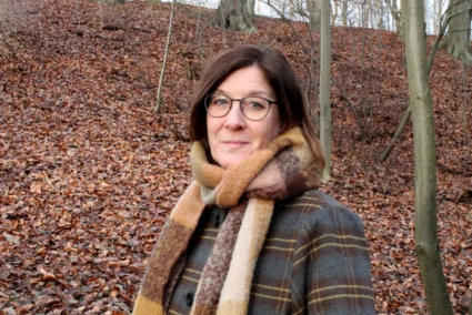 Kristina Lembke med halsduk i en skog om hösten.