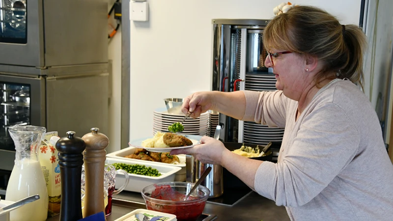 Lisa Fredriksson hjälper till att servera de lunchgäster som önskar det.