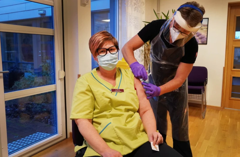 Undersköterskan Lina Larsson får sin andra dos av vaccin mot covid-19 av sjuksköterskan Jörgen Jönsson på Pålsjö Parks korttidsenhet.