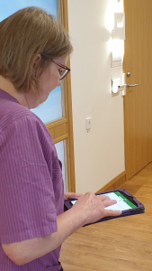 en kvinna i lila jobbtunika håller en ipad i handen