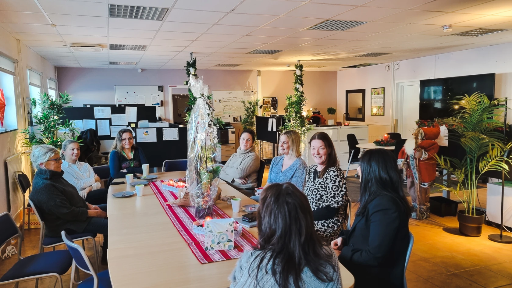 Deltagare i projekt digitala inköp sitter runt ett bord och fikar