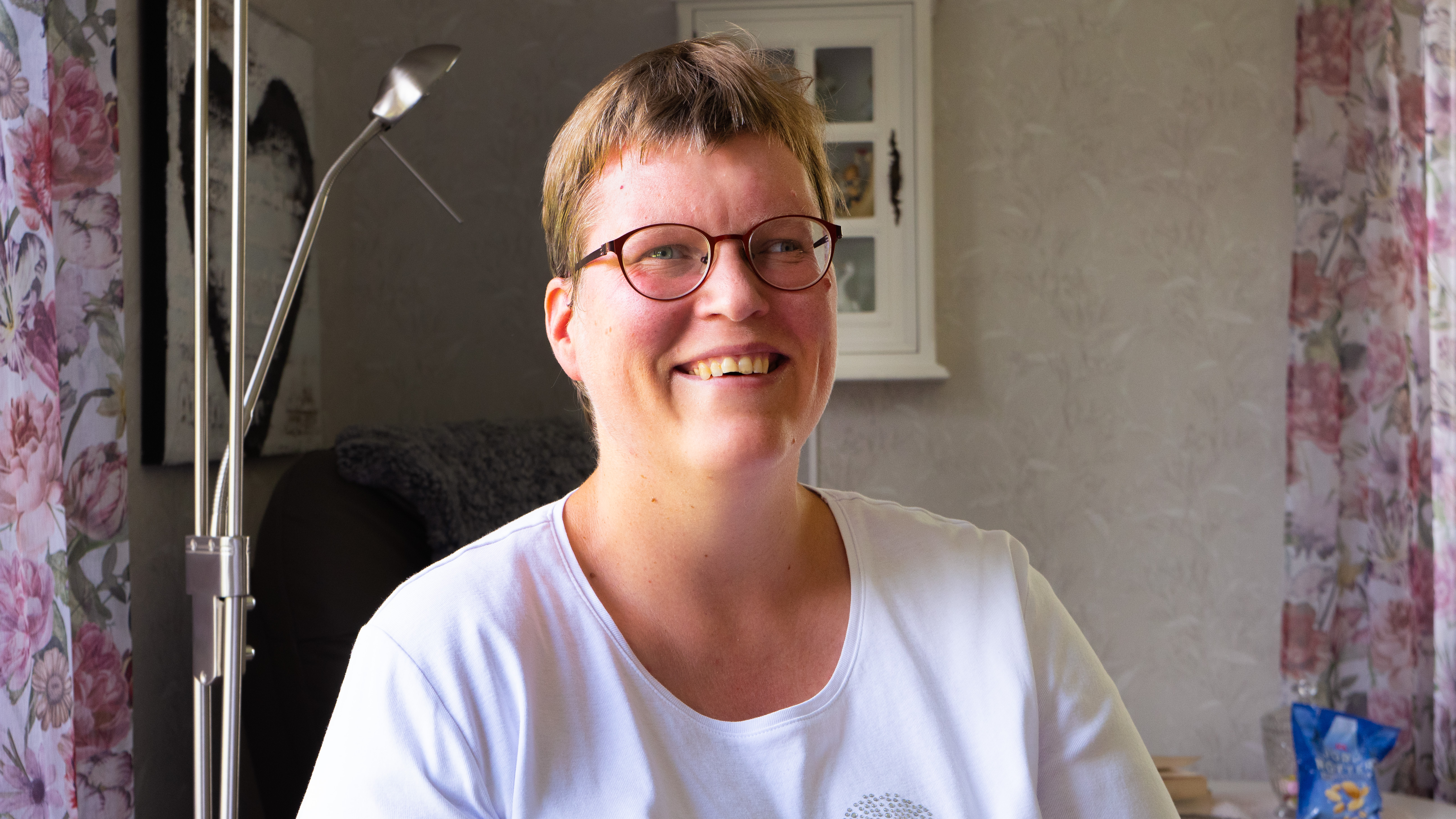 Kvinna som ler och ser in i kameran