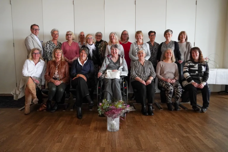 en grupp människor står på rad och tittar in i kameran