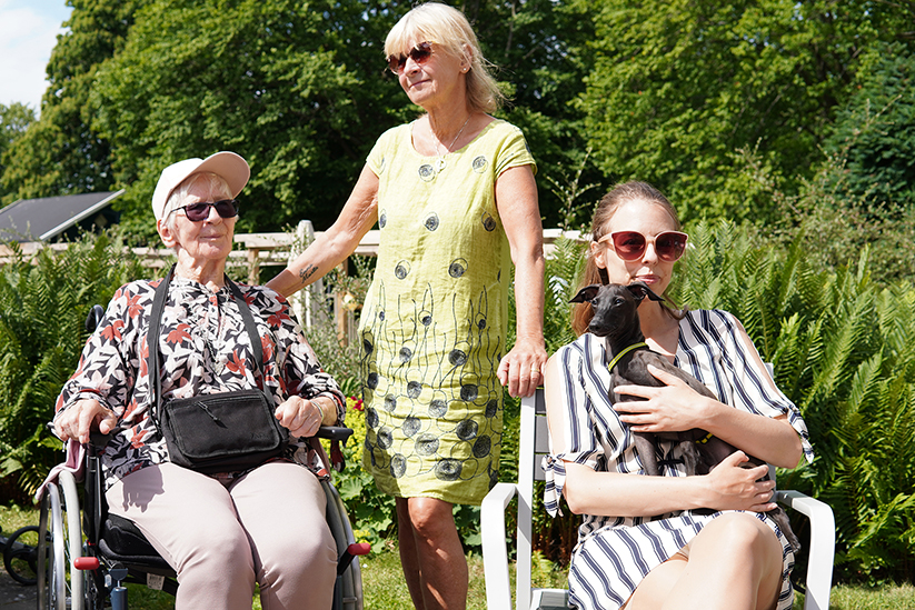 tre personer i olika generationer och en hund