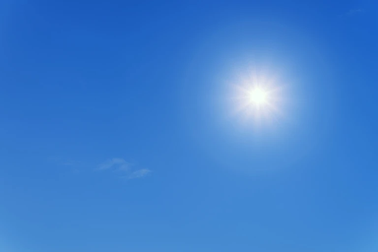 Sol som lyser på en blå himmel