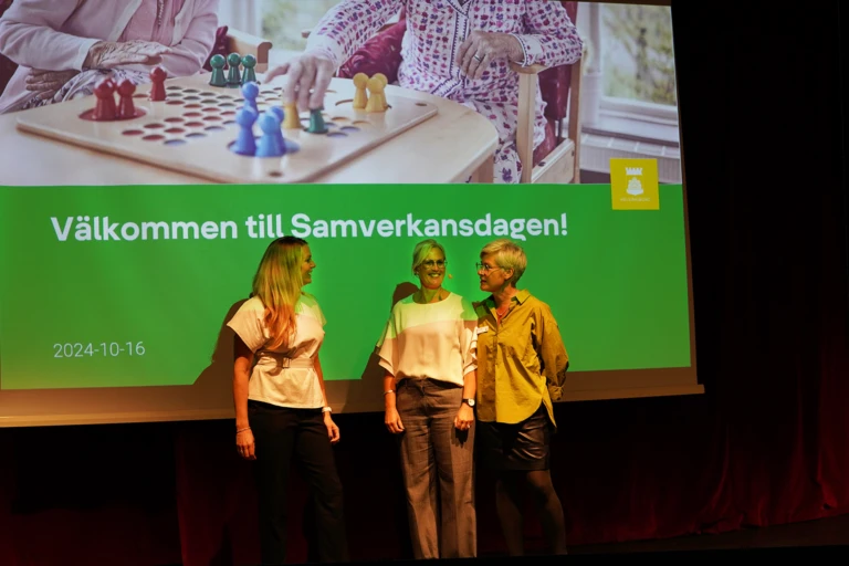 Tre personer står framför texten Välkommen till samverkansdagen