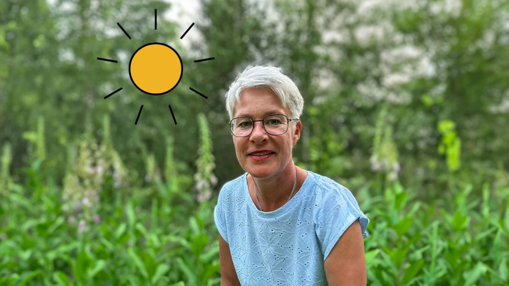 Kvinna sitter bland sommargrönska.