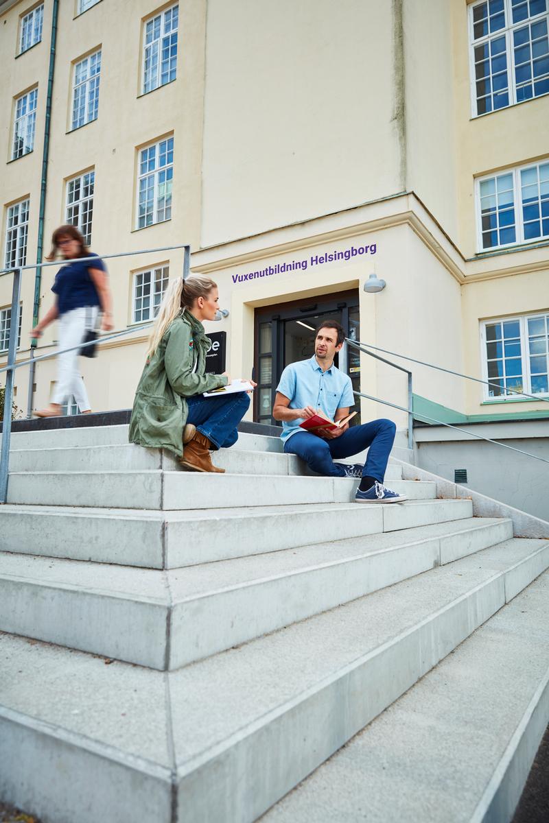 En man och en kvinna sitter på trappan utanför vuxenutbildningen i Helsingborg