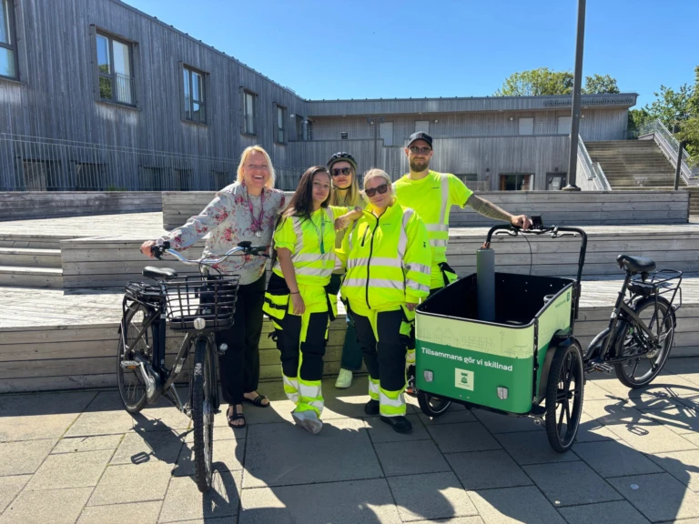 Glada personer som står bredvid två cyklar.