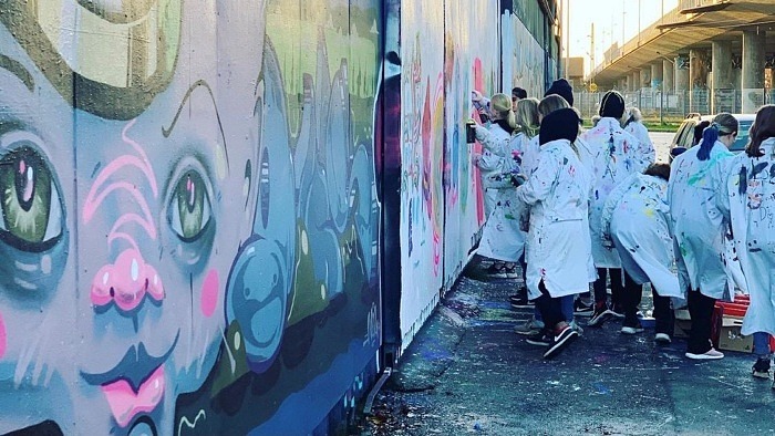 Barn som målar graffiti på en vägg utomhus