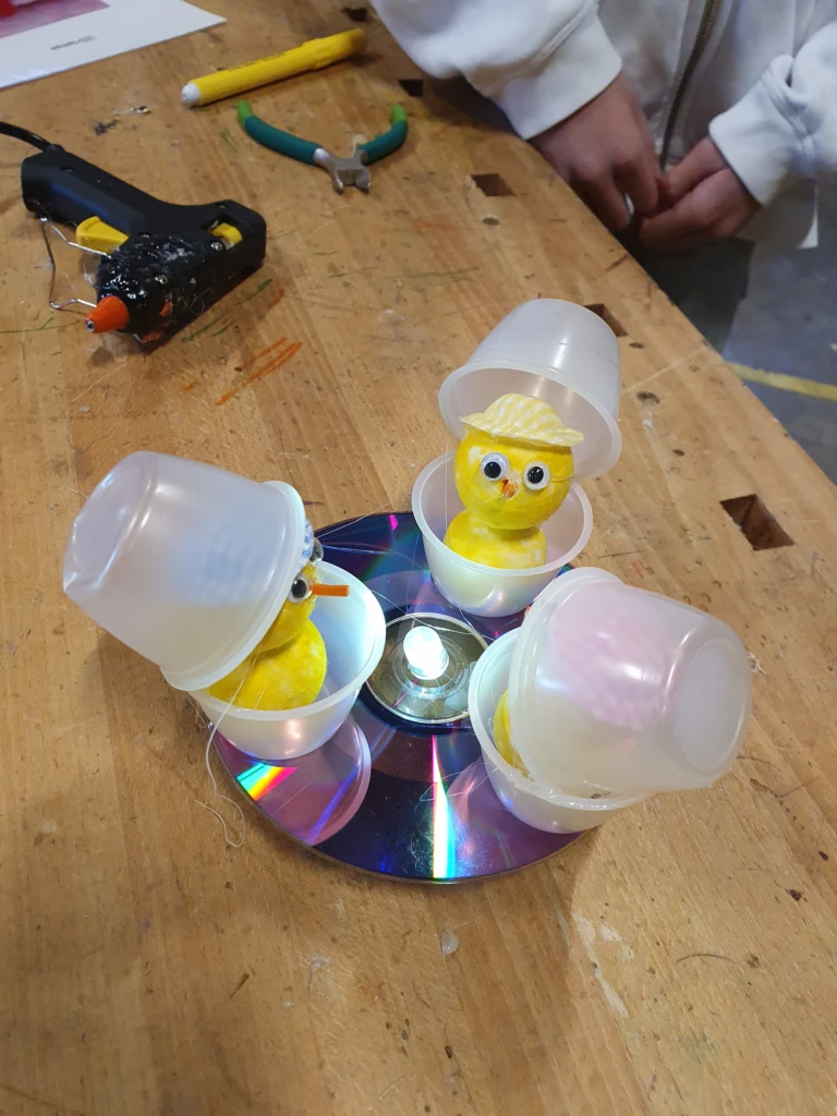 Ledlampa på en CD-skiva med 3 kycklingar i ring runt