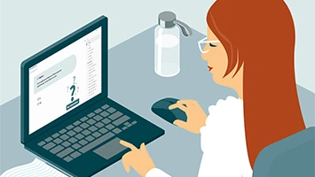 Kvinna som sitter vid en laptop och arbetar