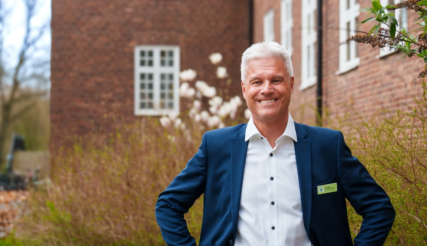 En bild på utbildningsdirektör Tony Mufic framför förvaltningskontoret.