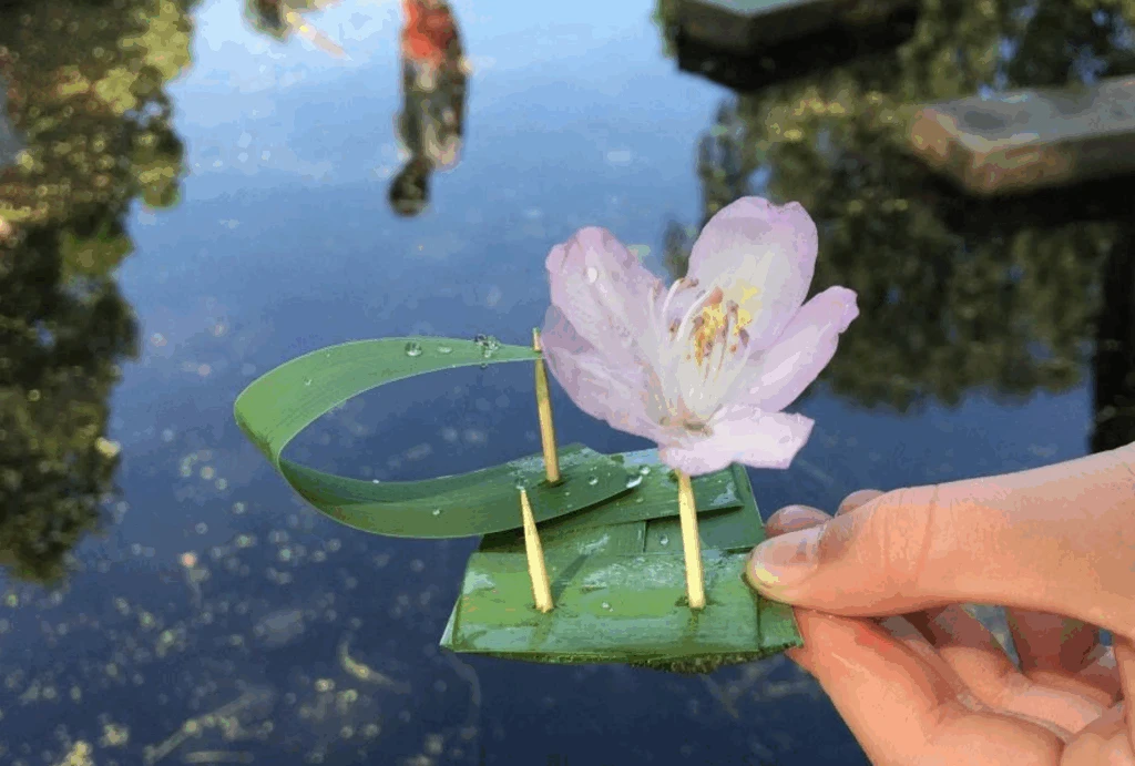 en hand som håller en blomma