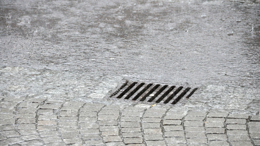 Regnvatten rinner ner i dagvattenbrunn