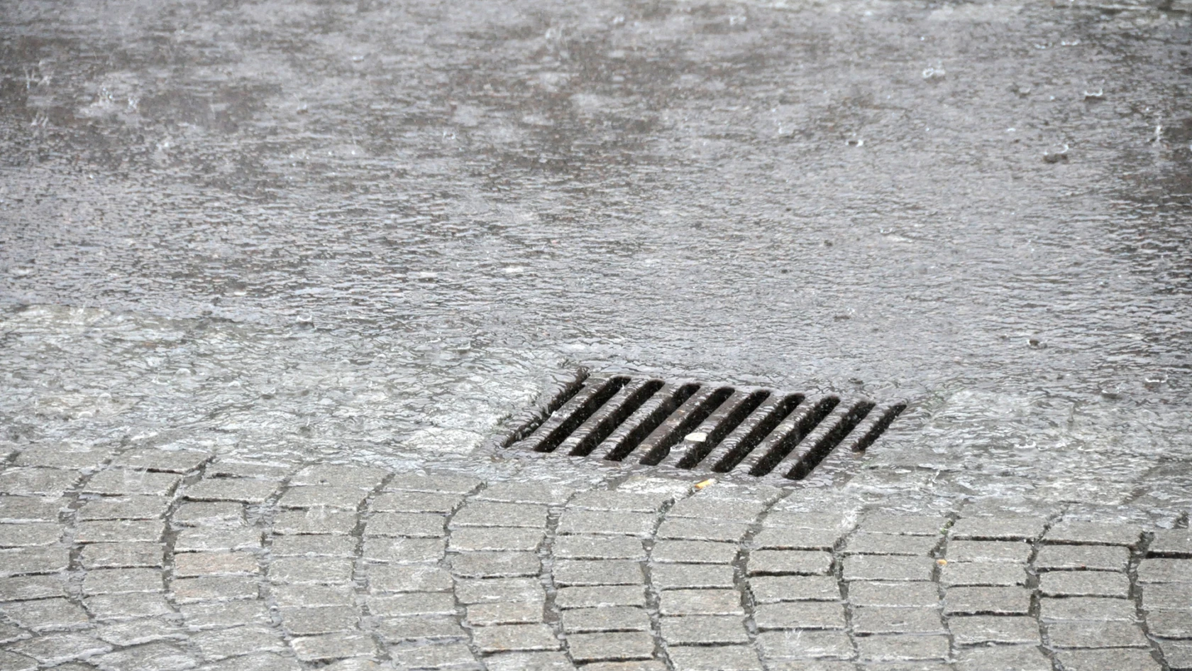 Regnvatten rinner ner i dagvattenbrunn